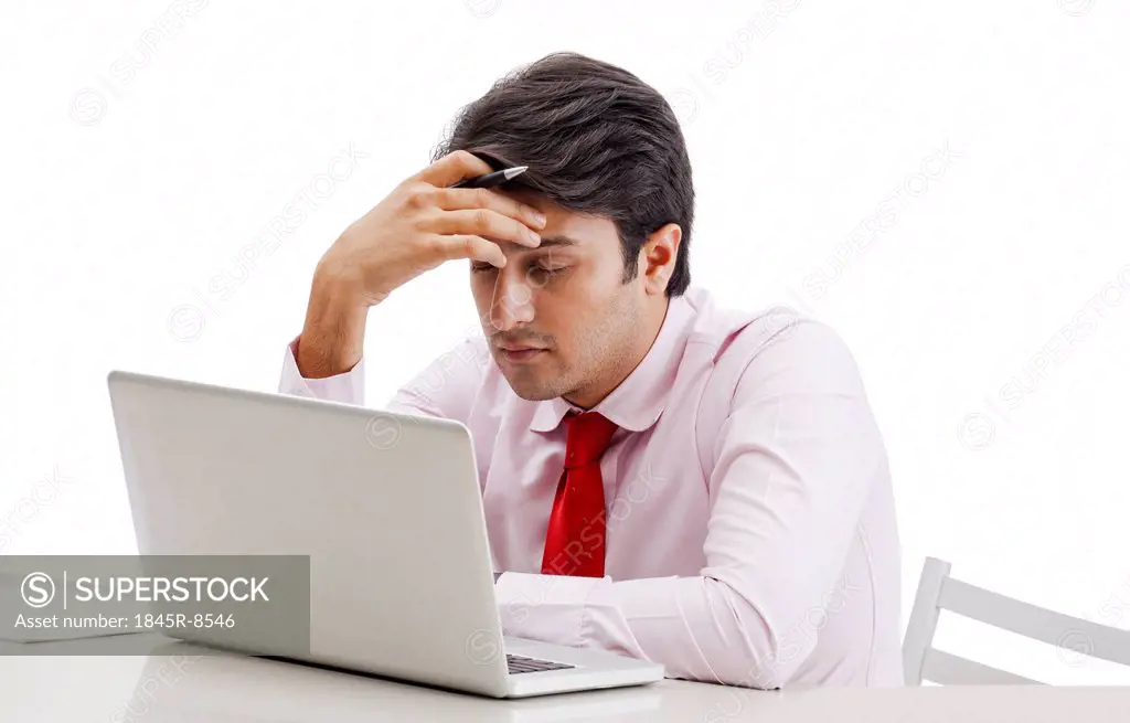 Businessman thinking in front of a laptop