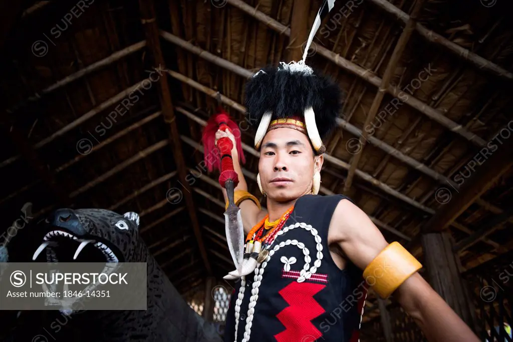 Naga tribal warrior in traditional outfit attacking with a spear, Hornbill Festival, Kohima, Nagaland, India