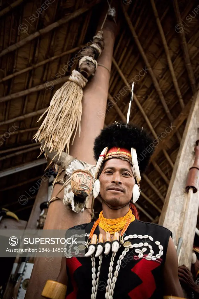 Naga tribal warriors in traditional outfit standing in front of a hut, Hornbill Festival, Kohima, Nagaland, India
