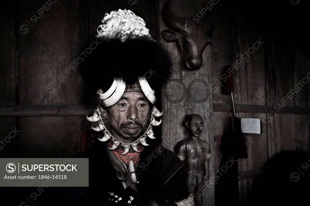 Naga tribal man in traditional outfit in a hut, Hornbill Festival, Kohima, Nagaland, India