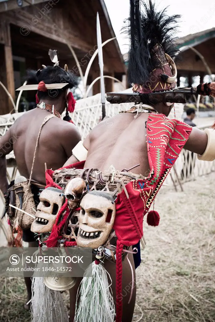 Rear view of two Naga tribal warriors in traditional outfit, Hornbill Festival, Kohima, Nagaland, India