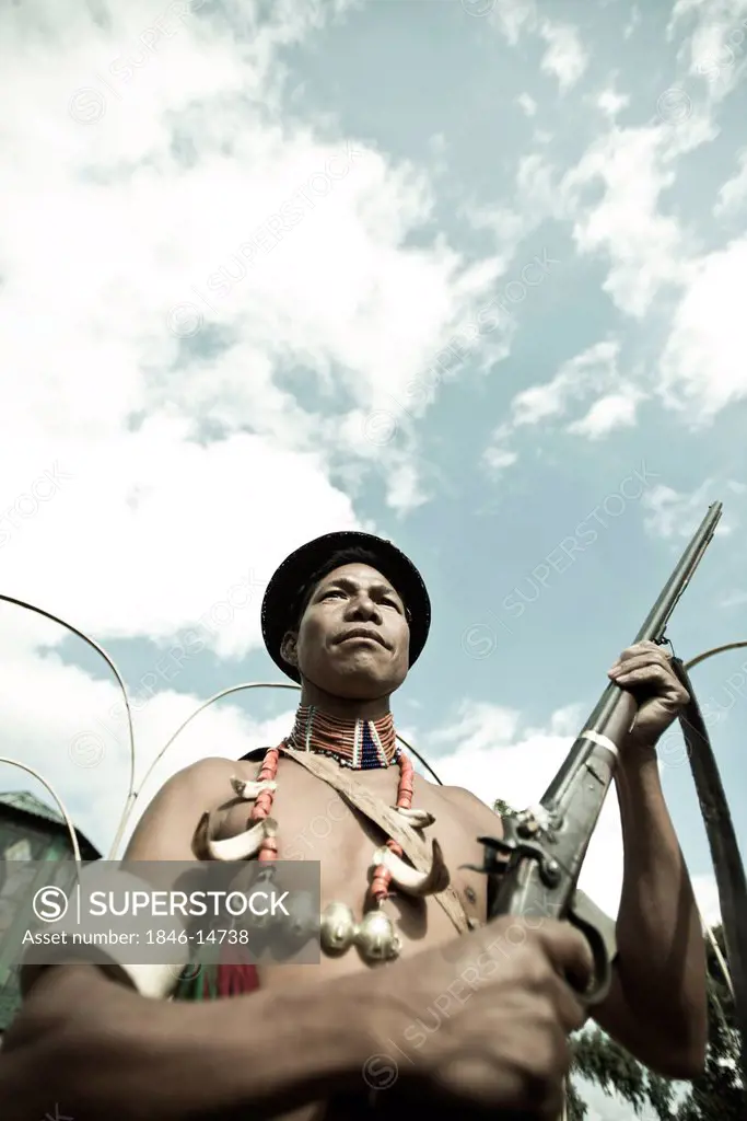 Naga tribesman holding a rifle during the annual Hornbill Festival at Kisama, Kohima, Nagaland, India