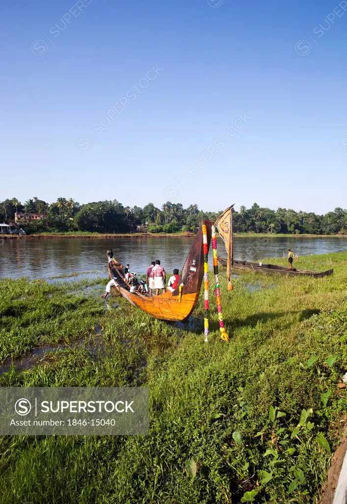 People in a snake boat at the riverside, Aranmula, Kerala, India