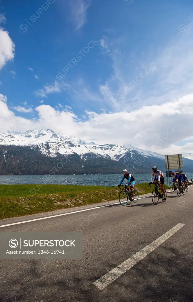 Cyclists riding bicycles on the road at lakeside, Como, Lombardy, Italy