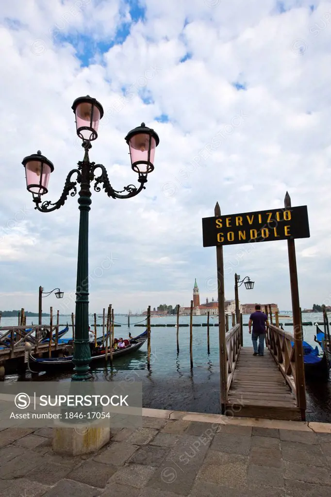 Lamppost next to a pier with gondolas at dock, Venice, Veneto, Italy