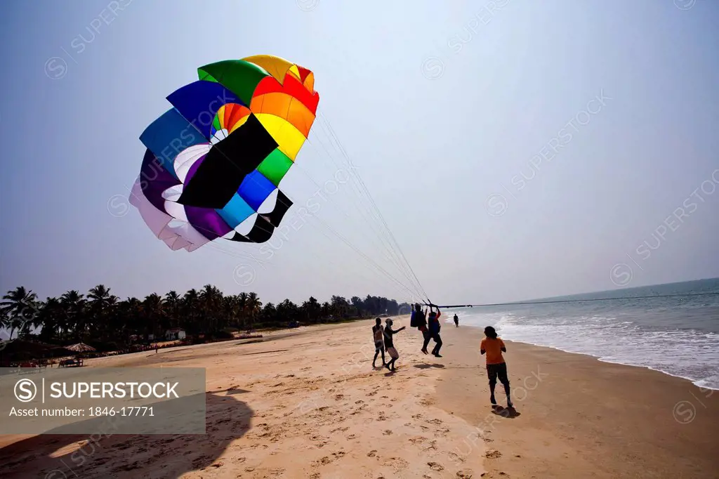 Tourists parasailing on a beach, North Goa, Goa, India