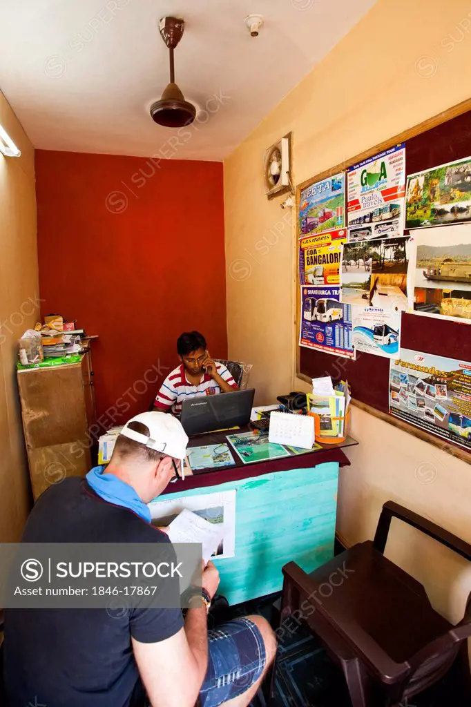 Man reading a brochure in the office of tour planner, Goa Tours Planner, Calangute, North Goa, Goa, India