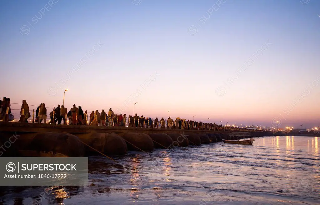 Pilgrims walking on a bridge over the Ganges River at Maha Kumbh, Allahabad, Uttar Pradesh, India