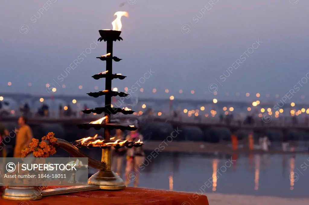 Burning oil lamp with River in the background at Maha Kumbh, Allahabad, Uttar Pradesh, India