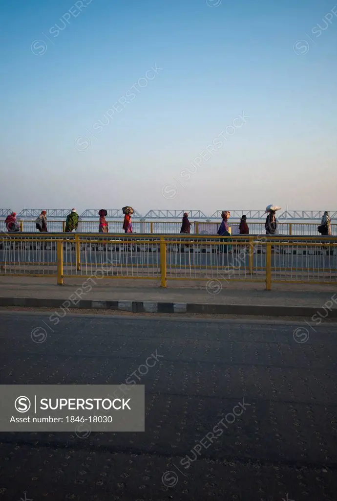 People walking over a bridge on Ganges River at Maha Kumbh, Allahabad, Uttar Pradesh, India