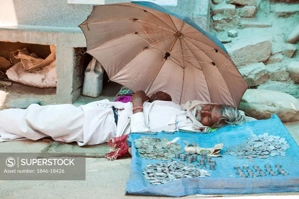 Beggar lying on a street, Haridwar, Uttarakhand, India