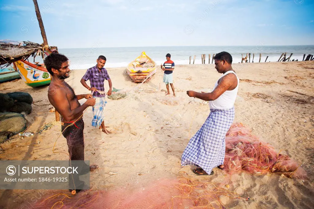 Fishermen holding fishing net on the beach, Pondicherry, India