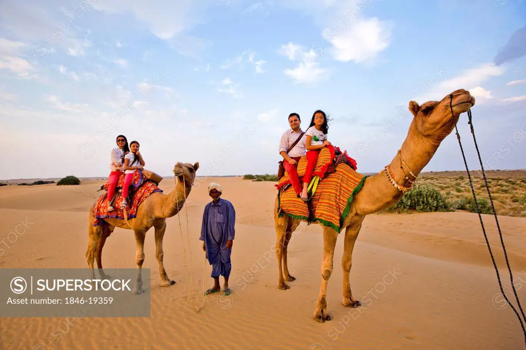 Tourists enjoying the camel safari in a desert, Thar Desert, Jaisalmer, Rajasthan, India