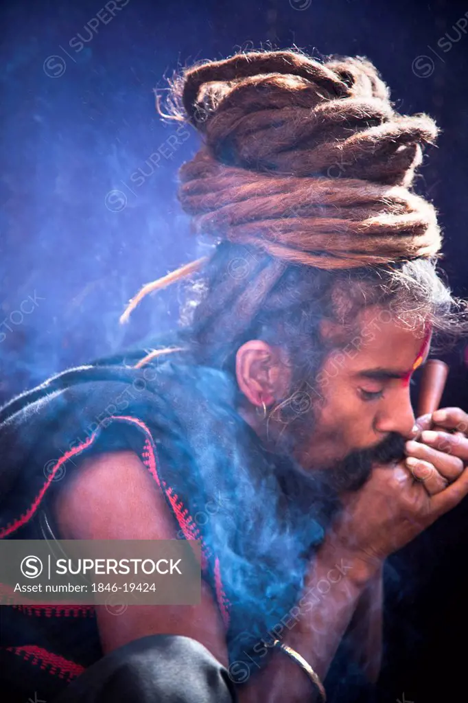 Sadhu smoking a chilam in Kumbha Mela, Allahabad, Uttar Pradesh, India