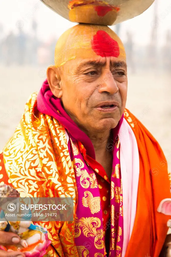 Sadhu balancing a stainless steel pot on his head during Kumbh Mela festival, Allahabad, Uttar Pradesh, India