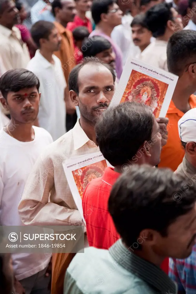 Hawker selling posters of Lord Ganesha at a religious procession, Mumbai, Maharashtra, India