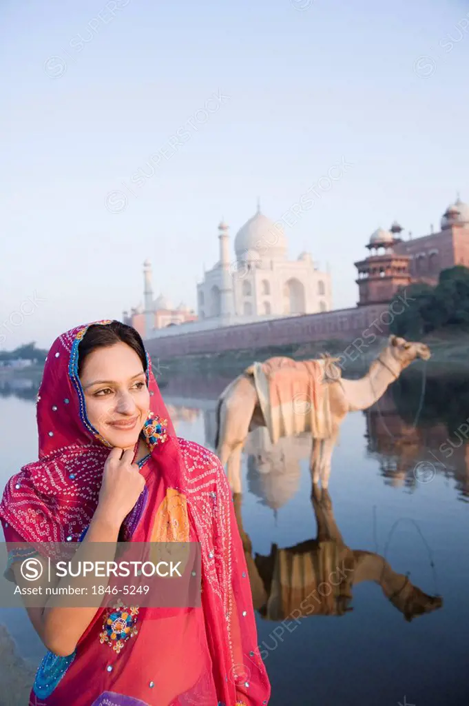 Woman at the riverbank with mausoleum in the background, Taj Mahal, Yamuna River, Agra, Uttar Pradesh, India