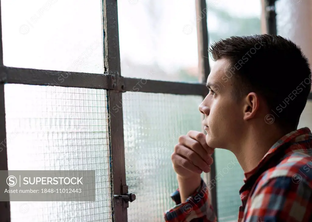 Young man looking out of a window