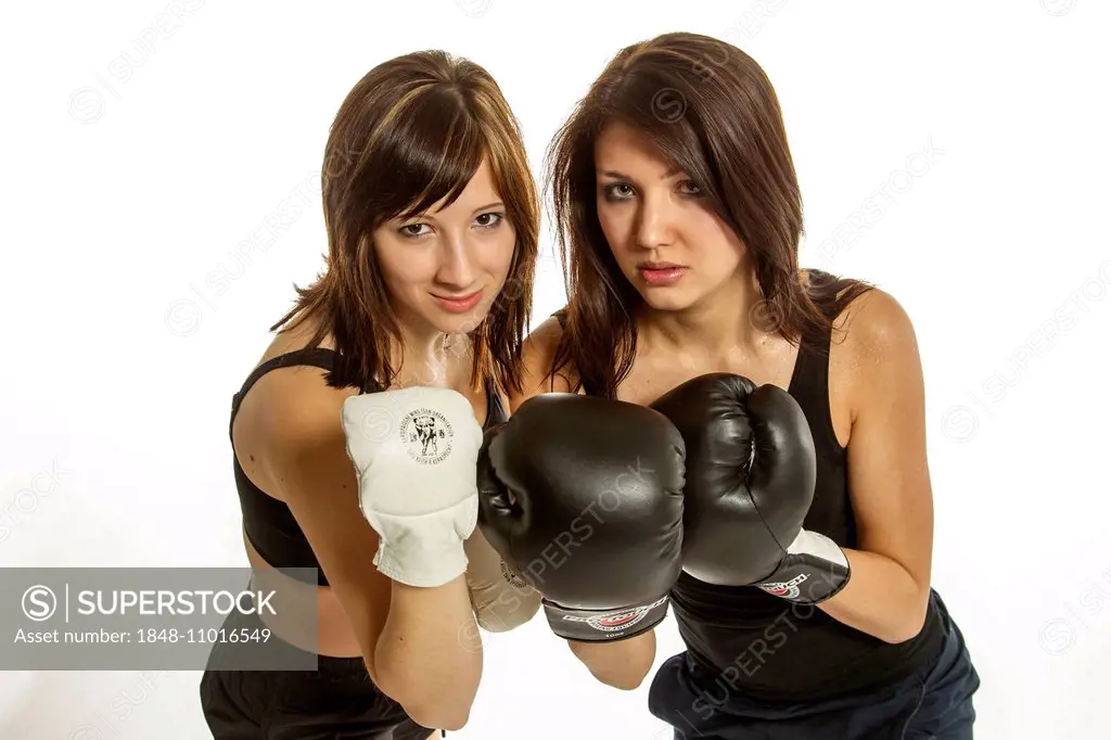 Two young women in sports clothing, one wearing Wing Chun gloves, the other wearing boxing gloves