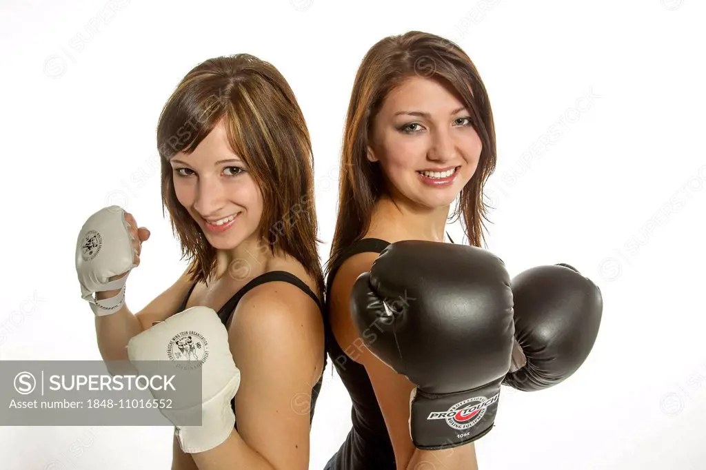 Two young women in sports clothing, one wearing Wing Chun gloves, the other wearing boxing gloves