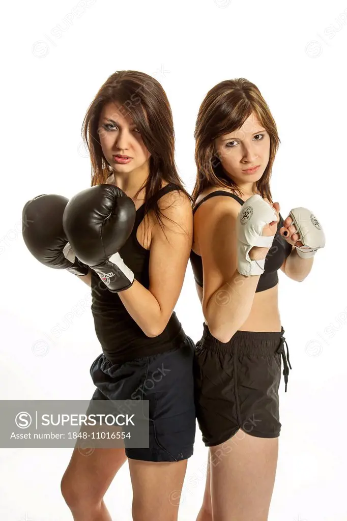 Two young women in sports clothing, one wearing boxing gloves, the other wearing Wing Chun gloves