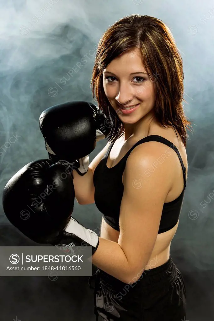 Young woman wearing sportswear and boxing gloves