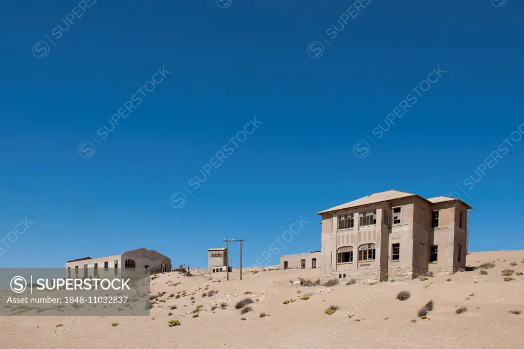 Houses of a former diamond miners settlement that is slowly covered by the sand of the Namib Desert, Kolmanskop, Karas, Namibia