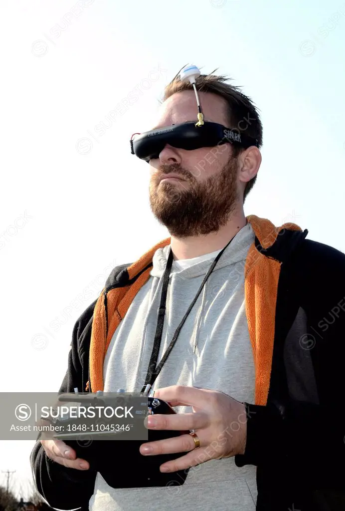 Man with FPV goggles and FUTUBA operator console to control a drone
