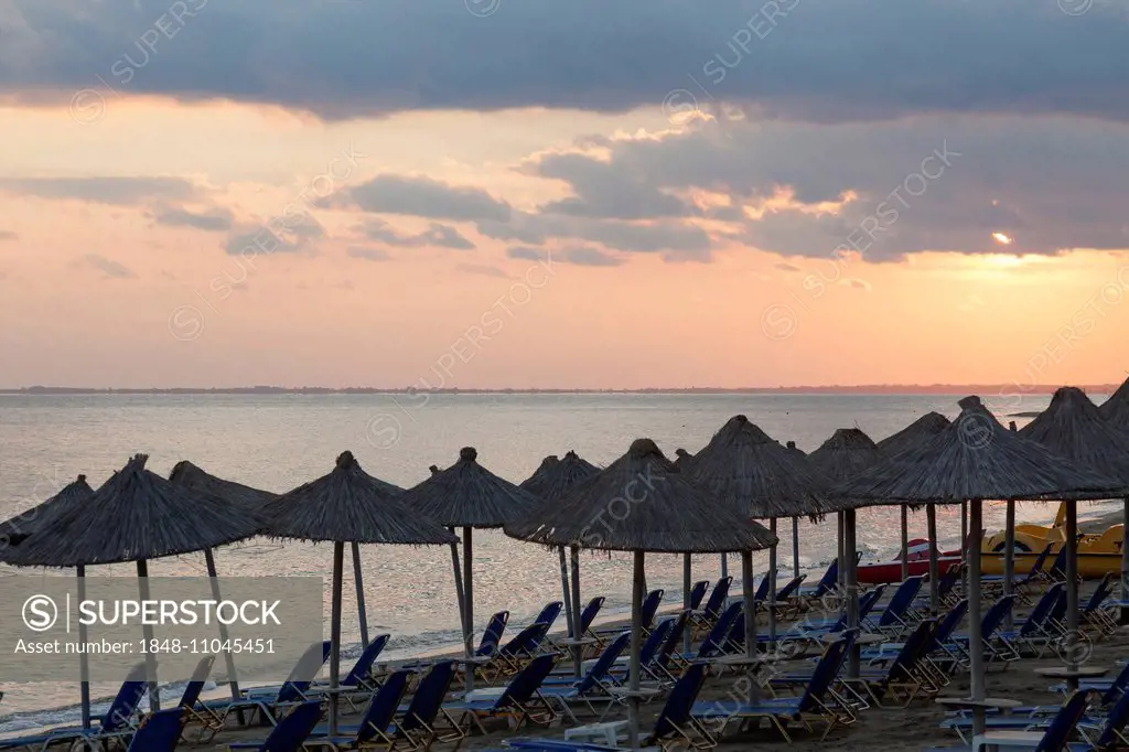 Parasols and sun loungers on the beach, sunset, Psakoudia, Chalkidiki, Greece