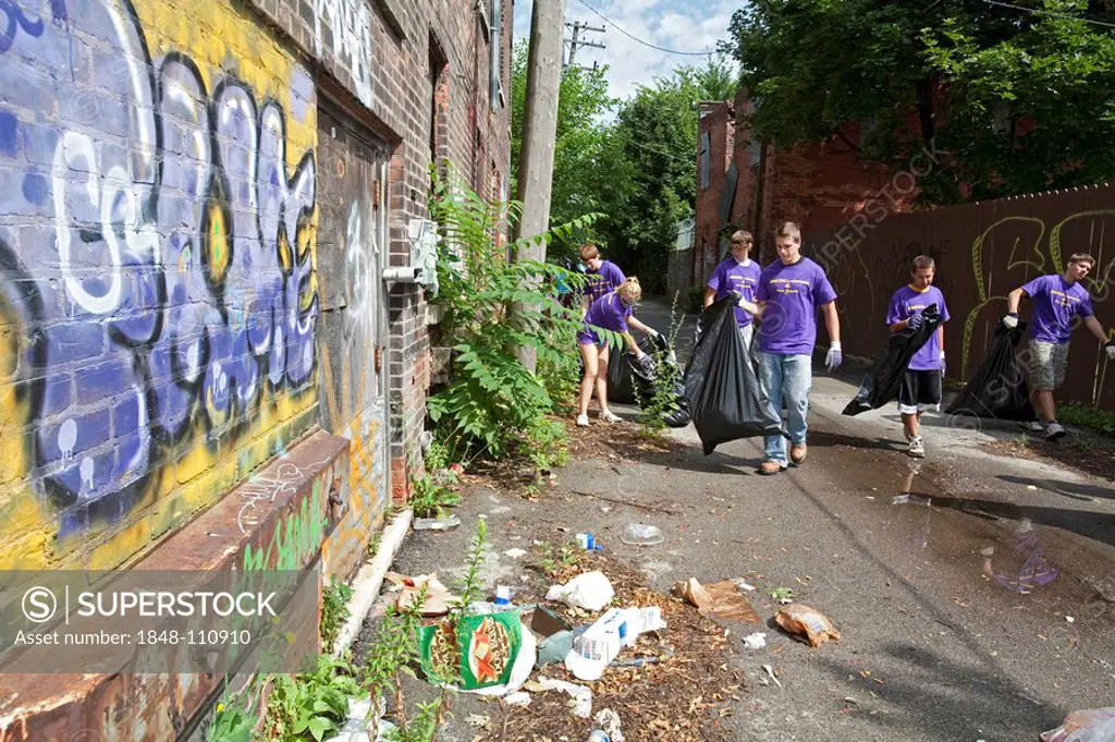 High school aged volunteers from St. Mary of the Hills Catholic church in Rochester Hills clean trash and debris from an alley in Detroit's Corktown n...