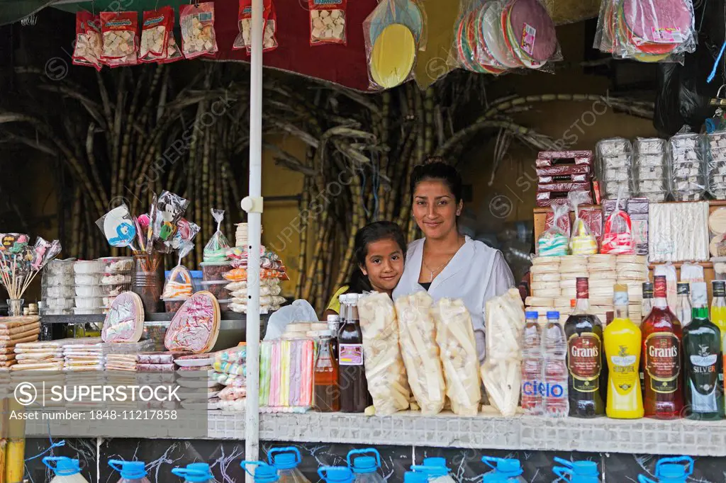 Mother, 25 years, and daughter, 7 years, selling sweets and drinks made from sugar cane, Puyo, Pastaza Province, Ecuador