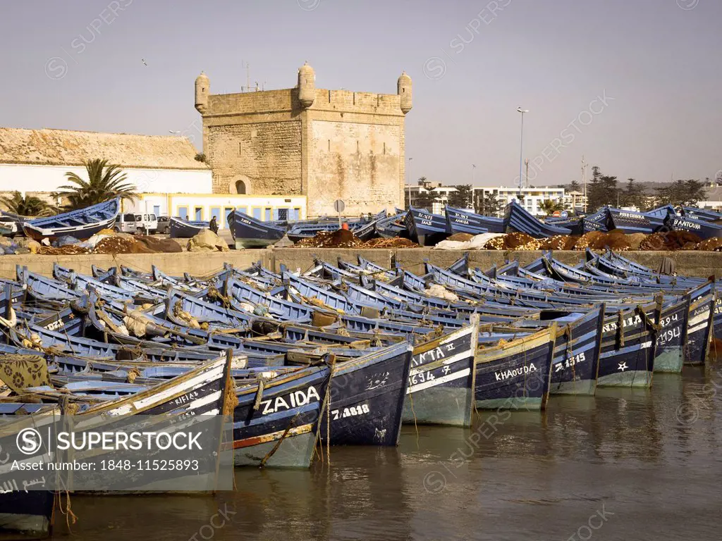 Old blue fishing boats in the port of Essaouira, behind the fortress of Essaouira, Unesco World Heritage Site, Morocco