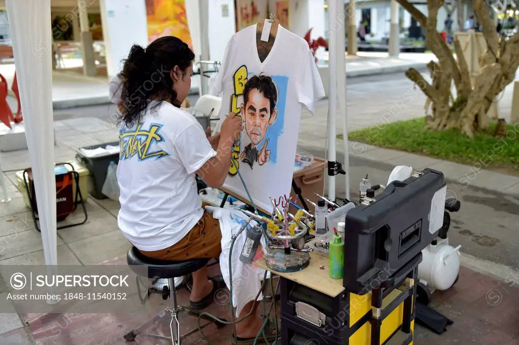 Woman airbrushing a portrait on a T-shirt, Hua Hin, Thailand