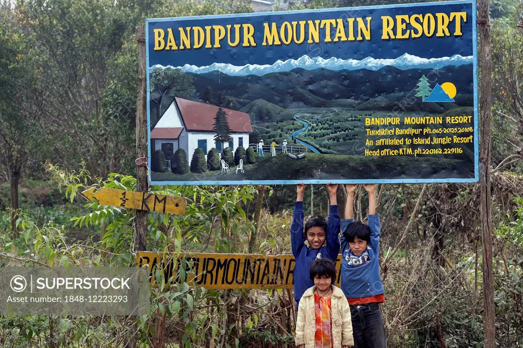 Children in front of a billboard for the Bandipur Mountain Resort, Bandipur, Nepal