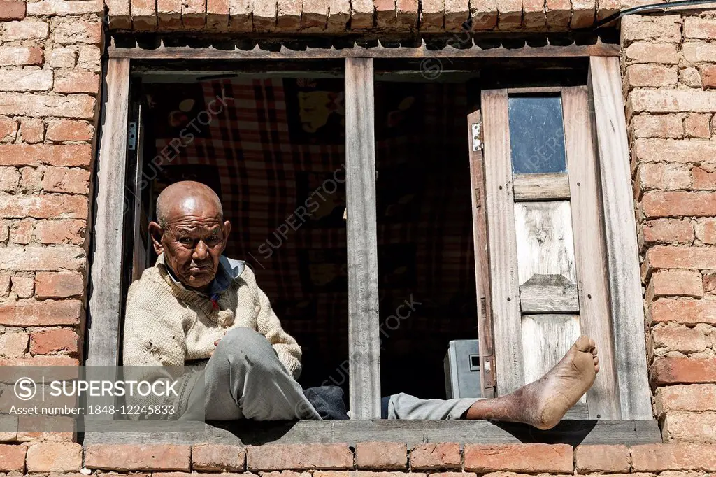 Nepalese man sitting at the window, at Nargakot, Nepal