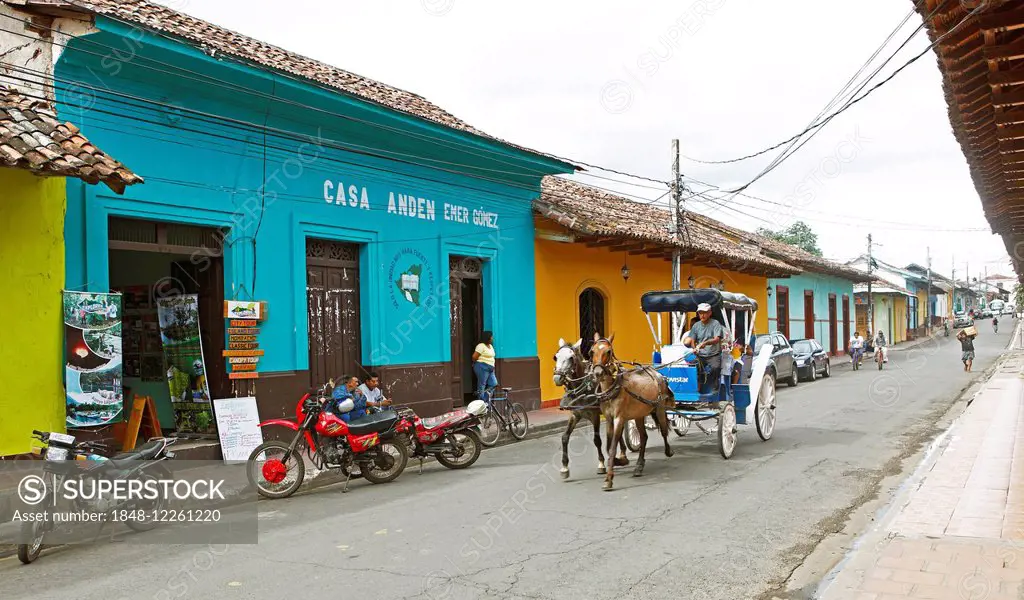 Colorful houses on a street, horse-drawn carriage passing by, Granada, province of Granada, Nicaragua