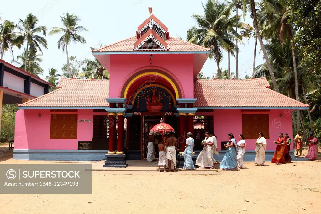 A group of women with offerings and a priest circling a Hindu temple, Varkala, Kerala, India