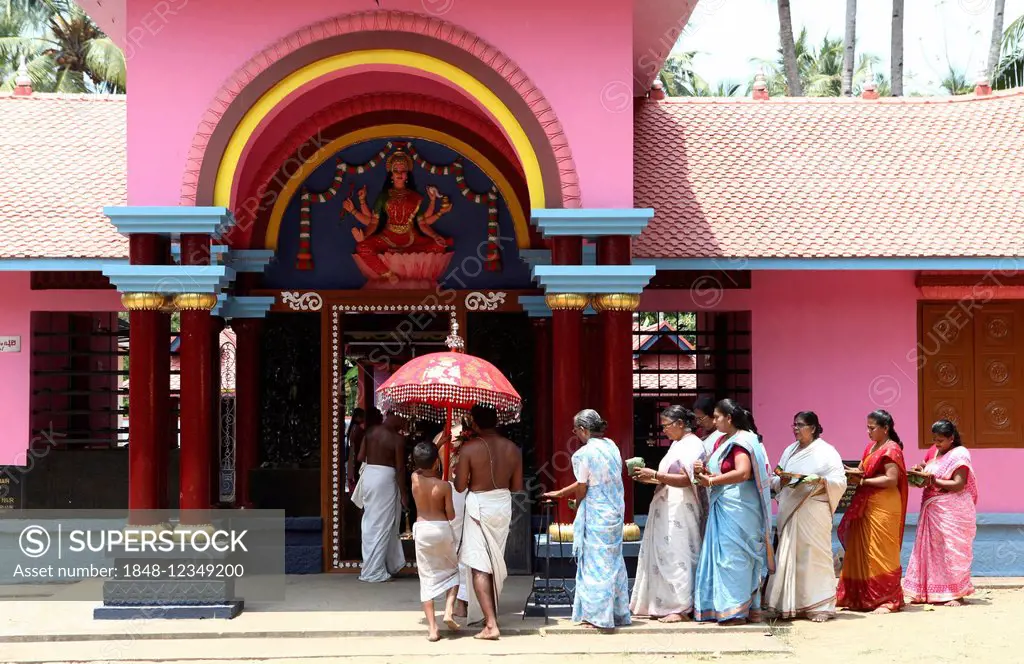 A group of women with offerings and a priest circling a Hindu temple, Varkala, Kerala, India