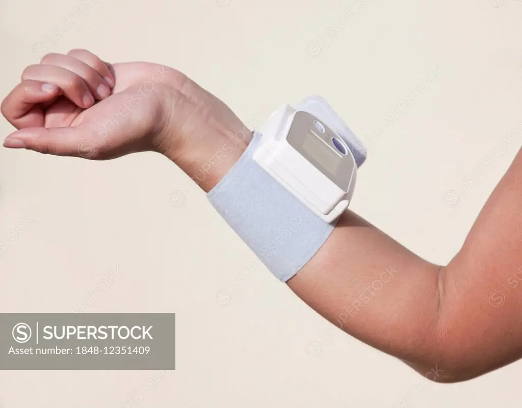 Forearm of a woman with an attached blood pressure monitor
