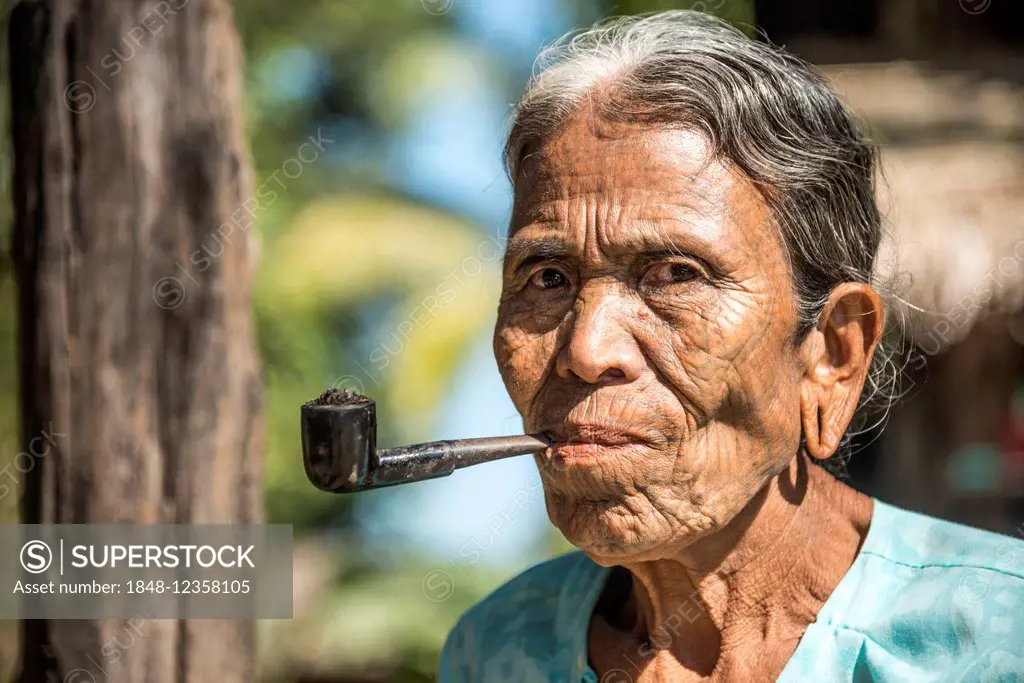 Woman of the Chin people, ethnic minority, with a traditional facial tattoo smoking a pipe, the last of their kind, portrait, Rakhine State, Myanmar