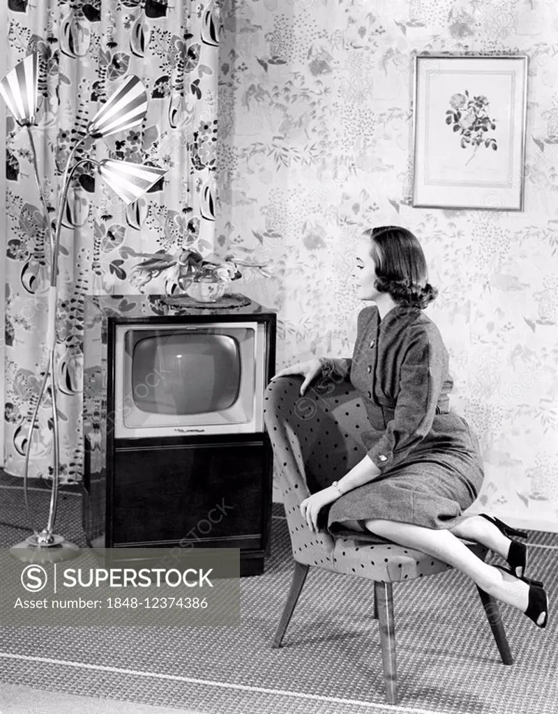 Woman posing next to a television, historic picture from about 1955