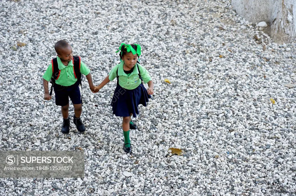 Boy and girl, siblings, holding hands on the way to the nursery school, Port-au-Prince, Ouest Department, Haiti