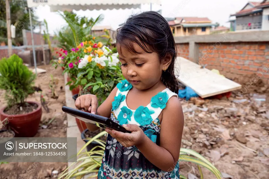 Little girl playing with a tablet computer, Phnom Penh, Cambodia