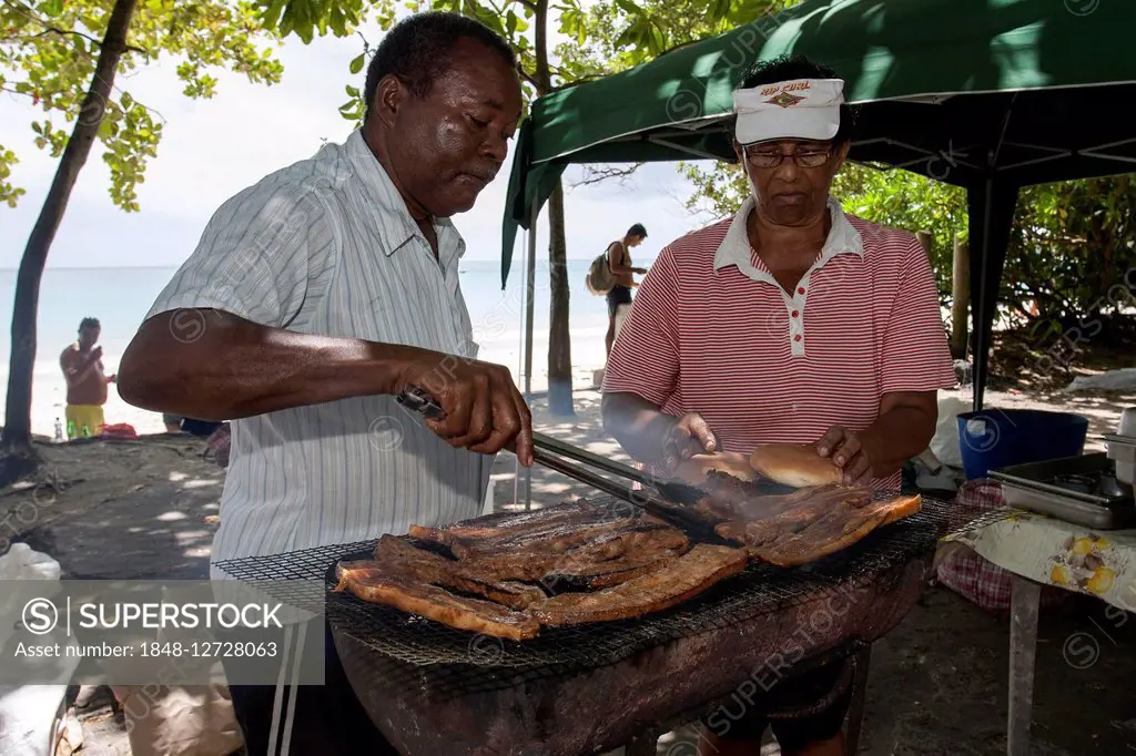 Street barbecue, indigenous man grilling meat on roadside, near Beau Vallon beach, Mahe Island, Seychelles