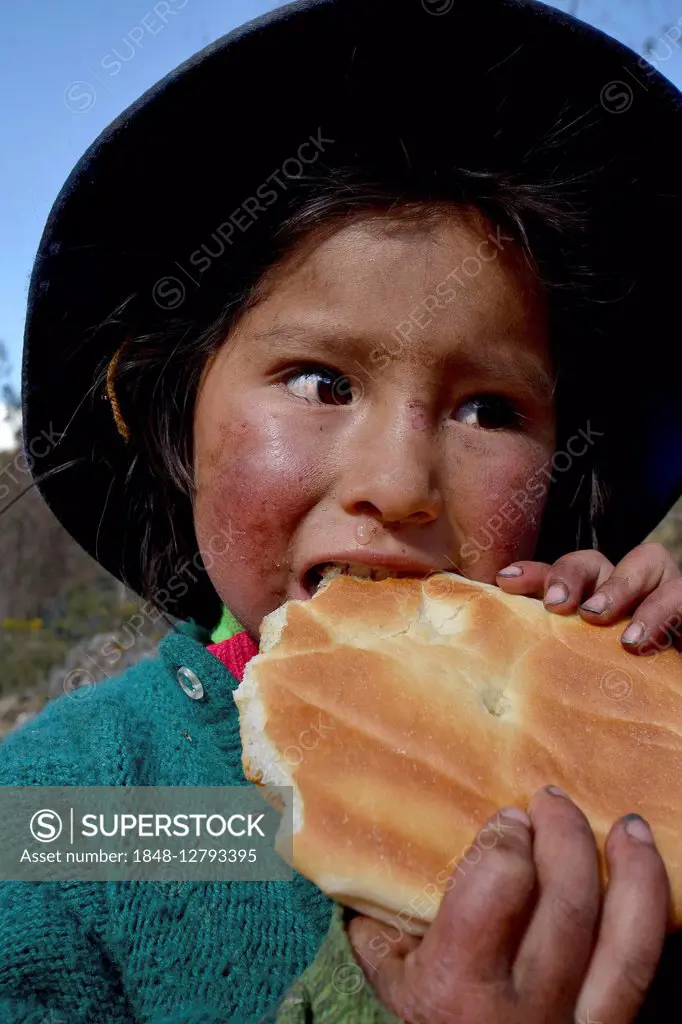 Native Peruvian girl eating bread, portrait, Cusco, Peru