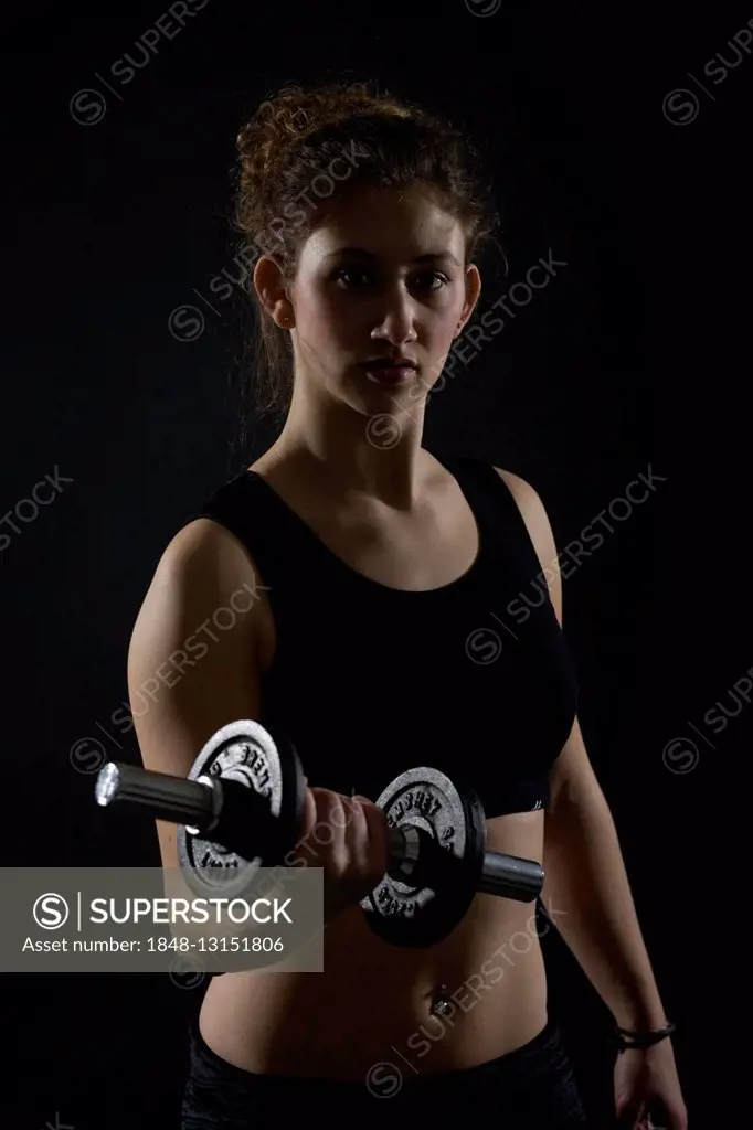 Young woman working out with dumbbells
