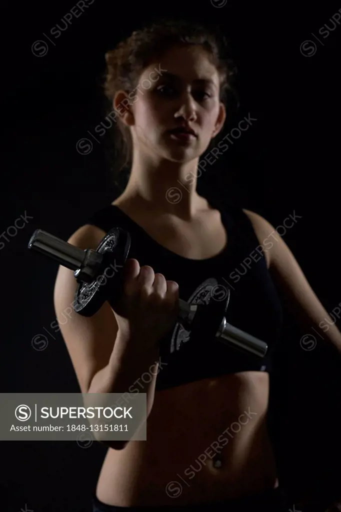 Young woman working out with dumbbells