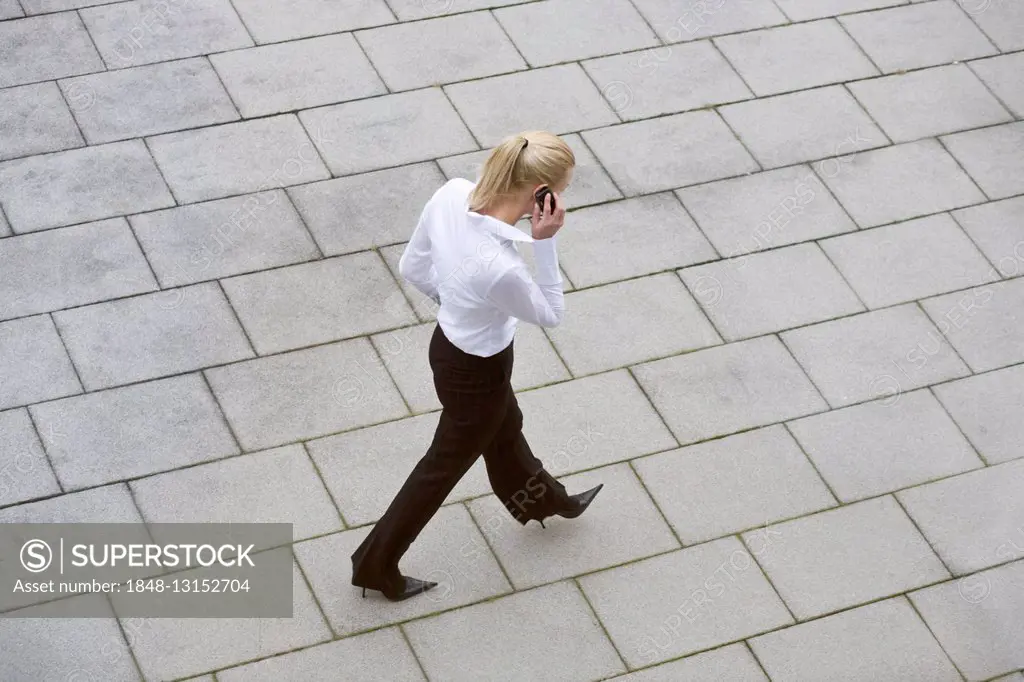 Businesswoman talking on phone as she walks