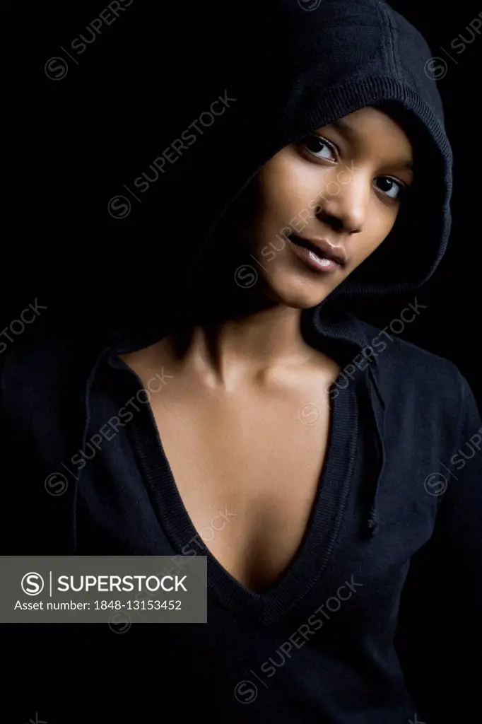 Dark-skinned, hooded woman, looking into the camera