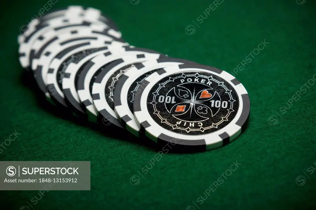 Black poker chips on green felt